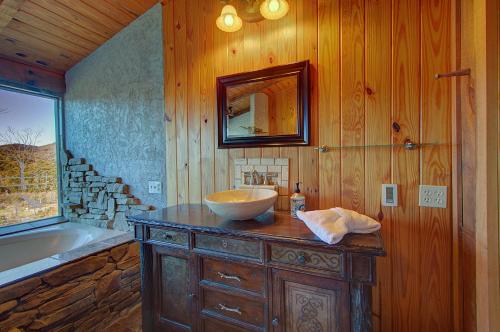 Un baño de madera con lavabo, bañera y lavabo. en Stunning Cabin: 7 Acres, 360 Views, 20min to Park!, en Sevierville