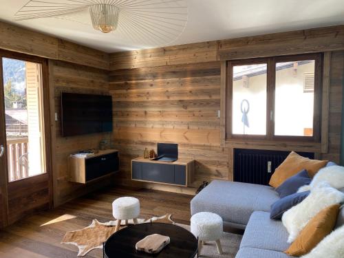 梅傑夫的住宿－A place 2 be, Megève centre，客厅设有木墙和蓝色沙发