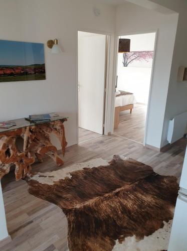 a living room with a wooden table and a fur rug at l’Écrin du Verger in Baldersheim