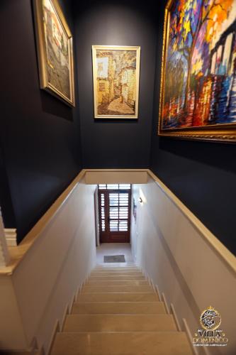 a stairway with paintings on the walls at Villa Domenico Korce in Korçë