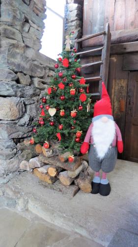 a santa claus figurine standing next to a christmas tree at Lo Gnomo sotto al Glicine in Châtillon