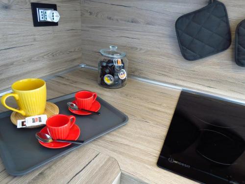 a tray with red cups and saucers on a table at Lo Gnomo sotto al Glicine in Châtillon