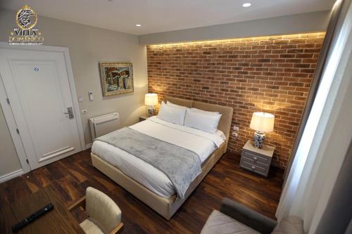 a bedroom with a brick wall and a bed at Villa Domenico Korce in Korçë