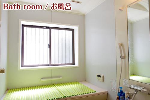 baño con ventana y ducha con suelo verde en NIKKO stay house ARAI - Vacation STAY 13830v en Nikko