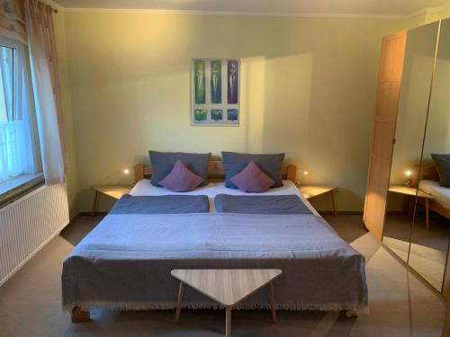 ヴェルニゲローデにあるMeine Ferienwohnungのベッドルーム1室(青いシーツと紫色の枕が備わるベッド1台付)