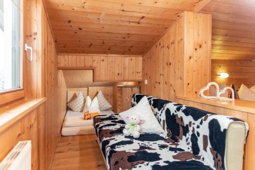 a living room with a cow print couch in a cabin at Wellnesshaus Reichelt in Radstadt