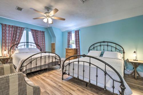 two beds in a bedroom with blue walls and a ceiling fan at Beachside Getaway - Walk to Gulf, Pier and Casino! in Gulfport