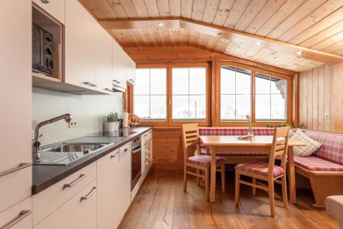 a kitchen and dining room with a table and chairs at Wellnesshaus Reichelt in Radstadt