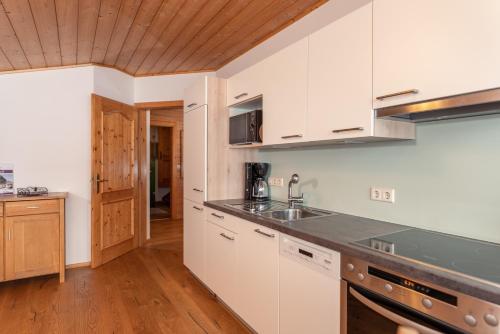 a kitchen with white cabinets and a counter top at Wellnesshaus Reichelt in Radstadt