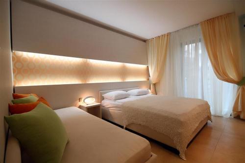 a hotel room with two beds and a window at Domador Rooms & Apartments in Budva