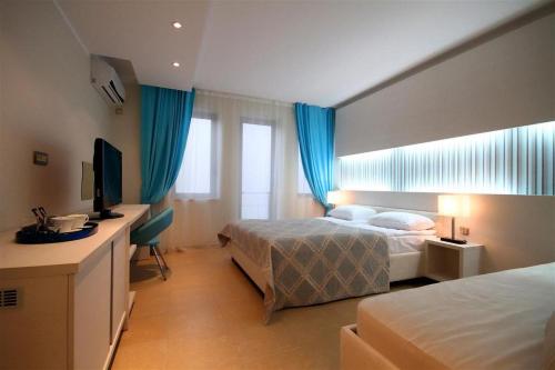 a hotel room with two beds and a television at Domador Rooms & Apartments in Budva