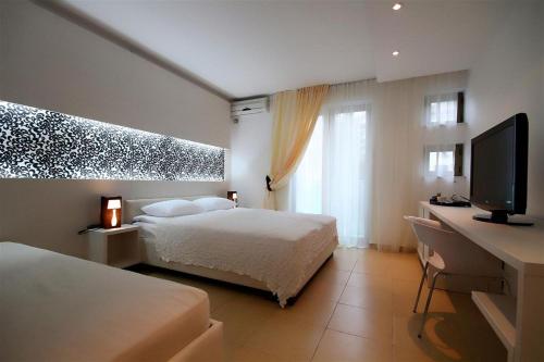 a bedroom with two beds and a flat screen tv at Domador Rooms & Apartments in Budva