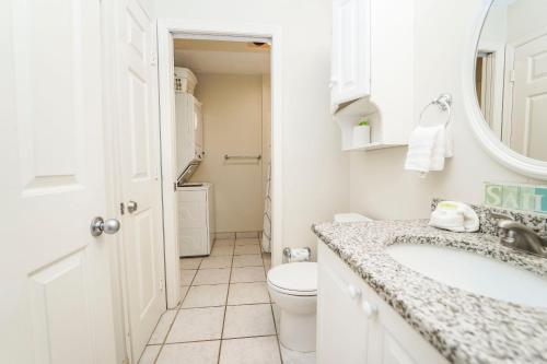 a white bathroom with a toilet and a sink at Coral Reef Club by Panhandle Getaways in Destin