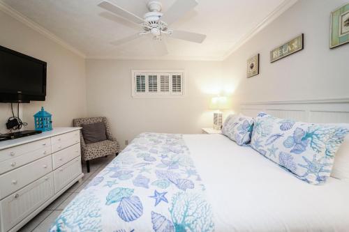 1 dormitorio con 1 cama y ventilador de techo en Coral Reef Club by Panhandle Getaways, en Destin