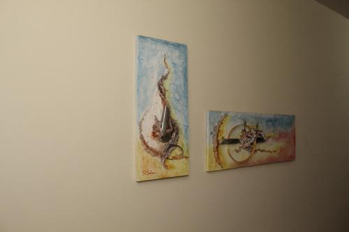 three paintings hanging on a wall at Grandes Lagos Park Hotel in Jales