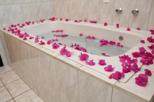 a bath tub filled with pink flowers on a counter at Grandes Lagos Park Hotel in Jales