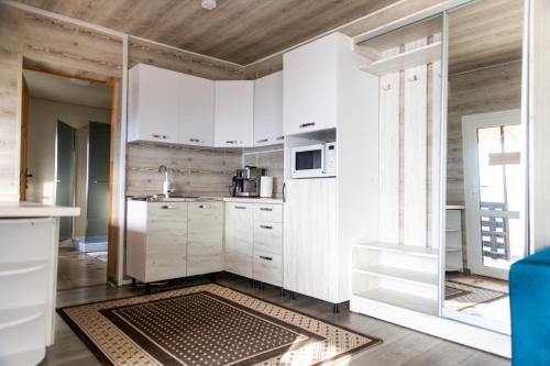 a kitchen with white cabinets and a kitchen rug at Садиба Кичера та Кичера Еко in Mizhhirʼʼya