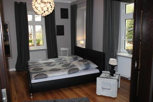 a bedroom with a bed and a chandelier and windows at Casa Hauth in Bernkastel-Kues