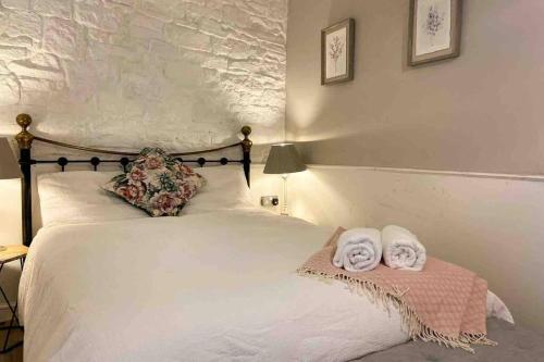 1 dormitorio con 1 cama con toallas en Coach House, en Keighley