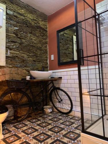 a bathroom with a sink and a bike in it at The Attic Apartment at Number 54 in Ilfracombe