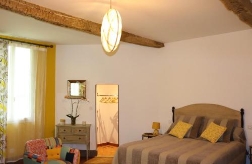 a bedroom with a bed and a chair at Maison D'hôtes Sainte-Marie in Mirande