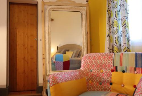 a mirror in a room with a couch and a bed at Maison D'hôtes Sainte-Marie in Mirande