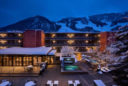 ein großes Gebäude mit einem schneebedeckten Berg im Hintergrund in der Unterkunft Aspen Square Condominium Hotel in Aspen