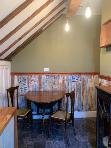 a kitchen with a table and chairs in a room at The Attic Apartment at Number 54 in Ilfracombe