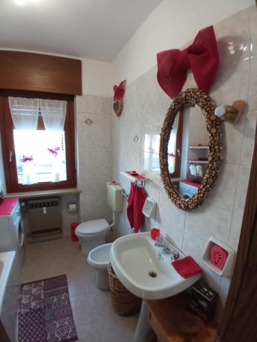 ein Badezimmer mit einem Waschbecken, einem WC und einem Spiegel in der Unterkunft Maison du Chasseur in Charvensod