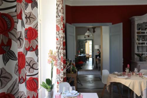 a dining room with a table and a room with a hallway at Maison D'hôtes Sainte-Marie in Mirande