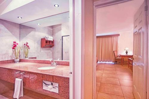 a bathroom with a sink and a large mirror at Hotel Arenas del Mar Resort in Tampico