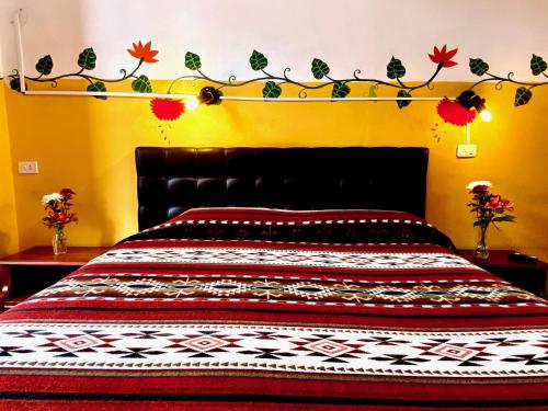 a bedroom with a large bed with a black headboard at Hostal Riviera Sucre in Otavalo
