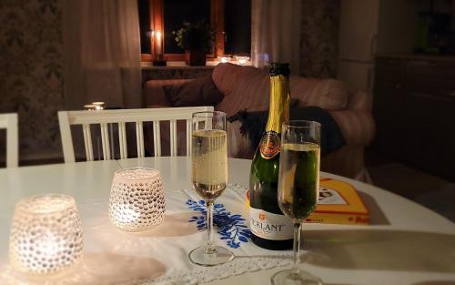 a bottle of champagne and two glasses on a table at Fridfullt läge mitt på Öland in Färjestaden