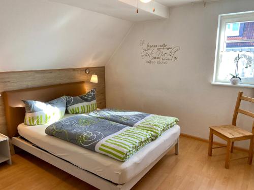 1 dormitorio con 1 cama, 1 silla y 1 ventana en Ferienwohnung 'Alte Schmiede', en Teningen