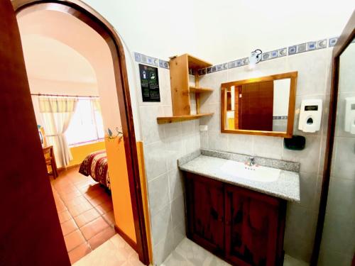 a bathroom with a sink and a mirror at Hostal Riviera Sucre in Otavalo
