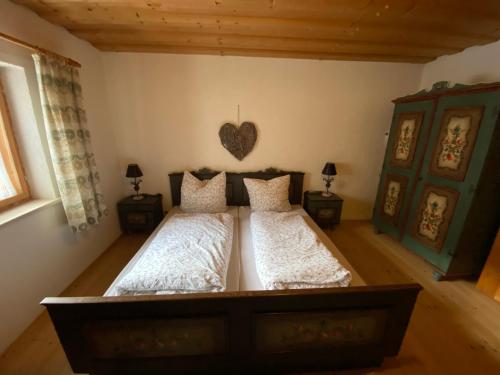 a bedroom with a large bed with a heart on the wall at Das Hexenhäusl in Schmitten