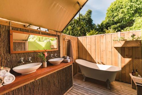 a bathroom with two sinks and a bath tub at Ikurangi Eco Retreat in Rarotonga