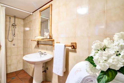 a bathroom with a sink and a toilet and flowers at A casa di Cinzia in Forte dei Marmi