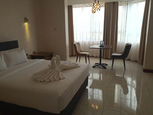 a hotel room with a bed and a table and chairs at Villa Grazia Luxury Hotel in Naivasha