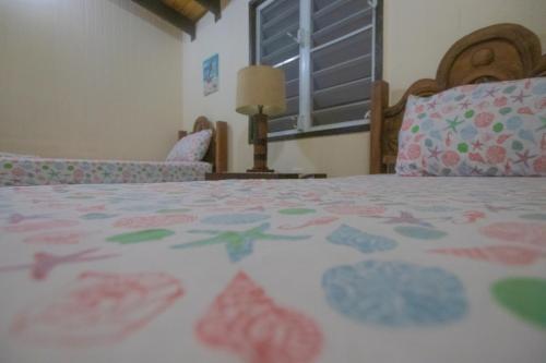 a bedroom with a bed with a comforter on it at Chalet Olas del Sol in Punta Santiago