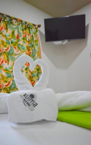 a pair of white gloves with a heart on a bed at Eco Hostal Kuima in El Zaino
