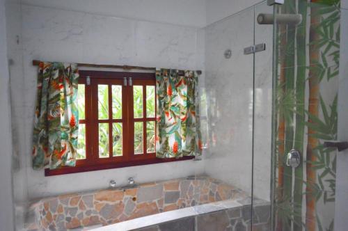 a bathroom with a shower and a window and a tub at Eco Hostal Kuima in El Zaino