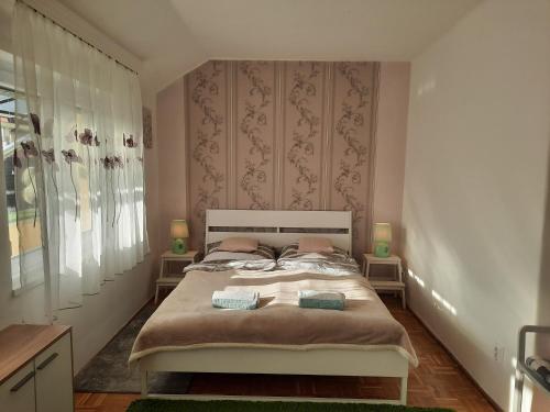 ein Schlafzimmer mit einem Bett mit zwei Kissen darauf in der Unterkunft Eszterlánc Apartman Eger in Eger