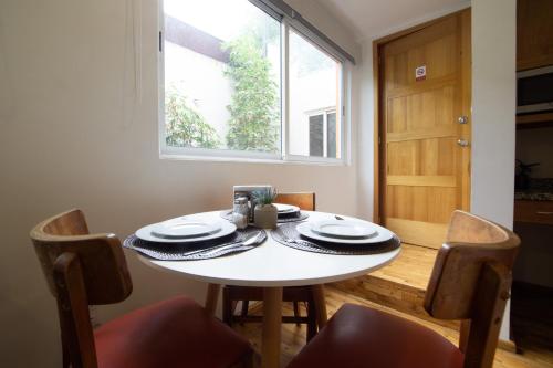a dining room table with chairs and a window at The Gallery in Mexico City