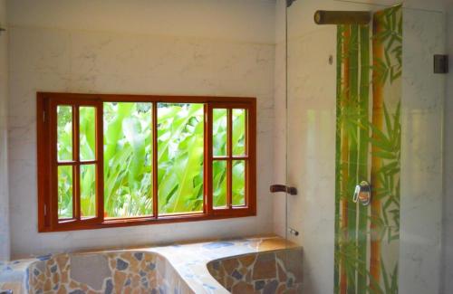 a bathroom with a window and a bath tub at Eco Hostal Kuima in El Zaino