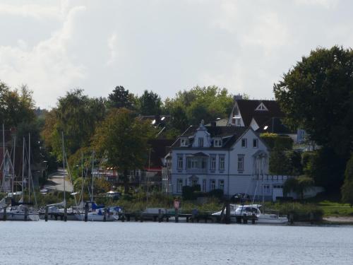a large white house on the shore of a body of water at Wohnen am Seglerhafen mit Traveblick im Kontorhaus viele Extras in Lübeck