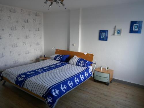 een slaapkamer met een bed met blauwe en witte lakens bij Wohnen am Seglerhafen mit Traveblick im Kontorhaus viele Extras in Lübeck