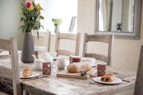 a wooden table with plates of food on it at Newly renovated Old bakery House in Bath, 3 Bedroom, FREE Parking in Bath