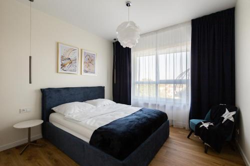 una camera con un grande letto e una finestra di JPapartments Blue przy plaży a Danzica