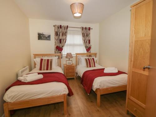 a bedroom with two beds with red and white sheets at Cadliam in Whitby